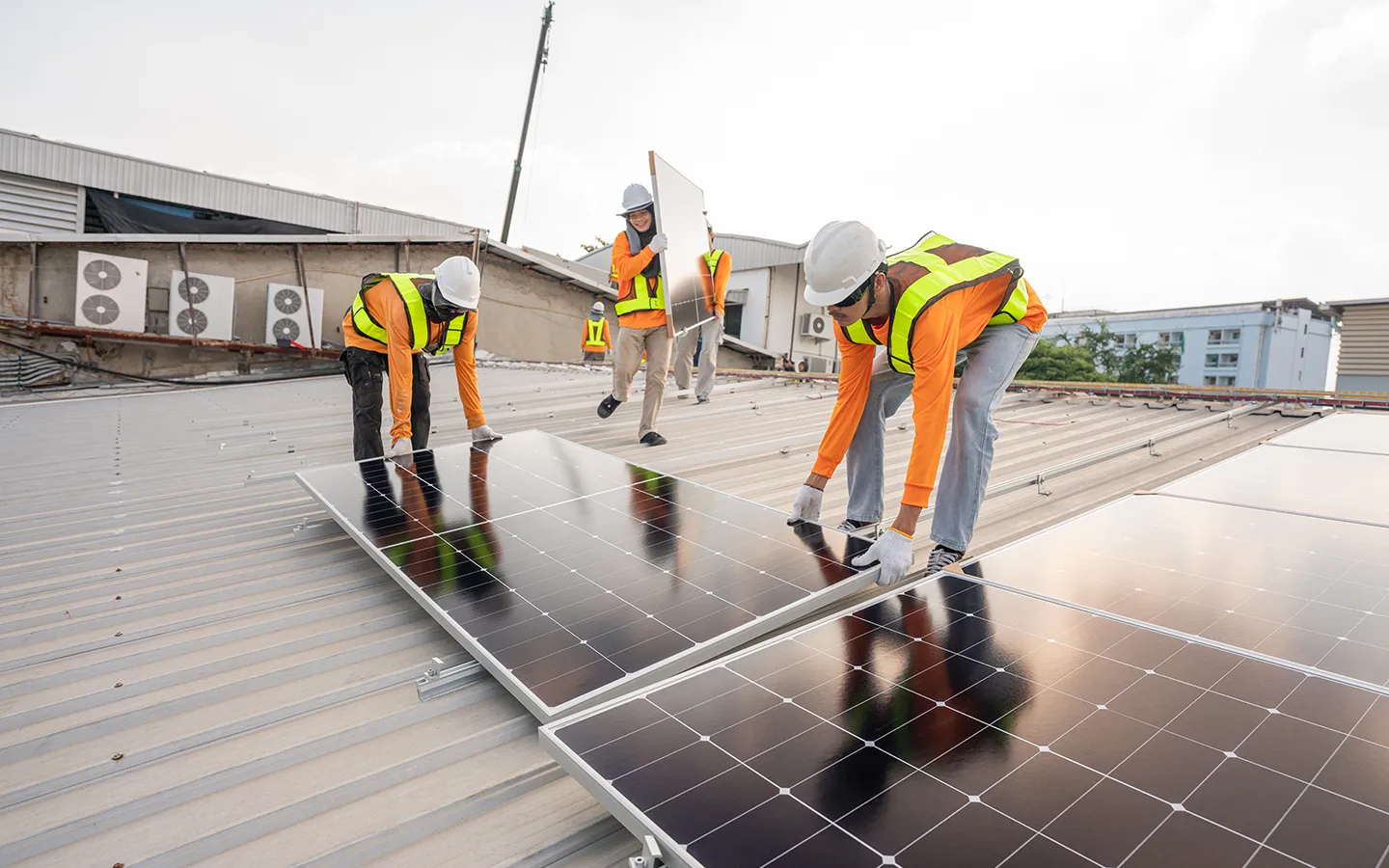 Installation team positioning solar panels on a rooftop in Rockhampton.