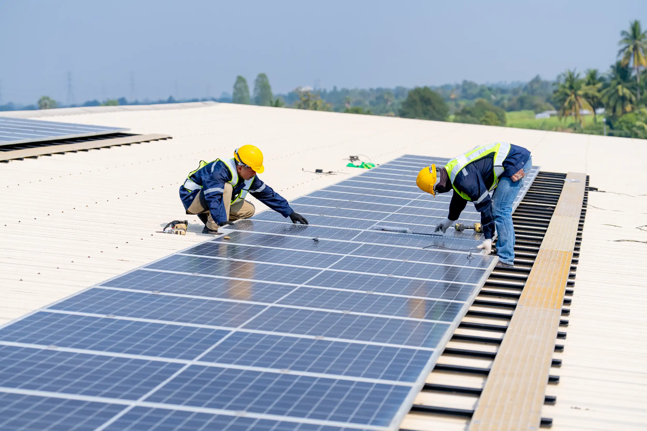 Solar technicians installing and aligning panels during a commercial solar project in Byfield.