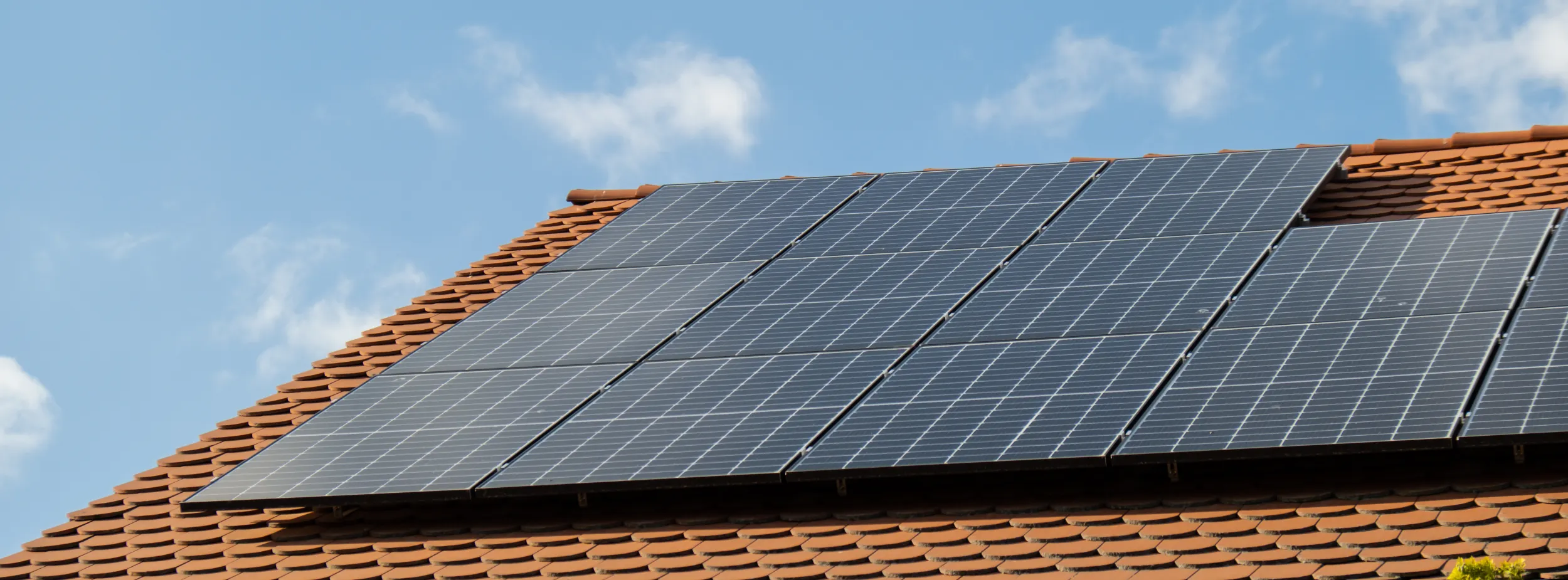 Residential solar panel array installed on a tiled rooftop, capturing sunlight under a clear blue sky in Parkhurst.